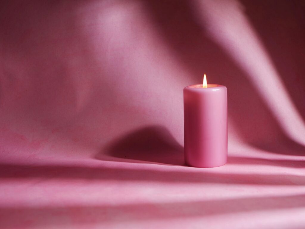 Romantic pink candle on pink background medium shot